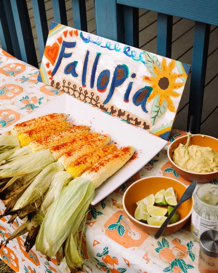 A platter of grilled corn on a table with the Fallopia sign