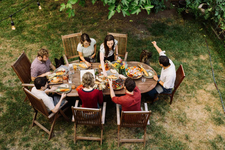 Phil and his housemates seated around the table in their backyard eating dinner