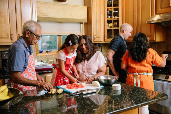 Rachita Sharma and family cooking in kitchen.