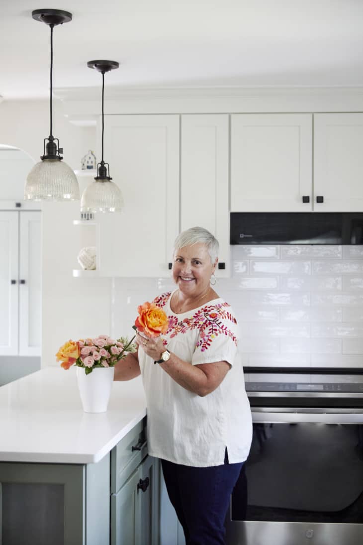 Peggy Barresi in her kitchen making floral arrangements.
