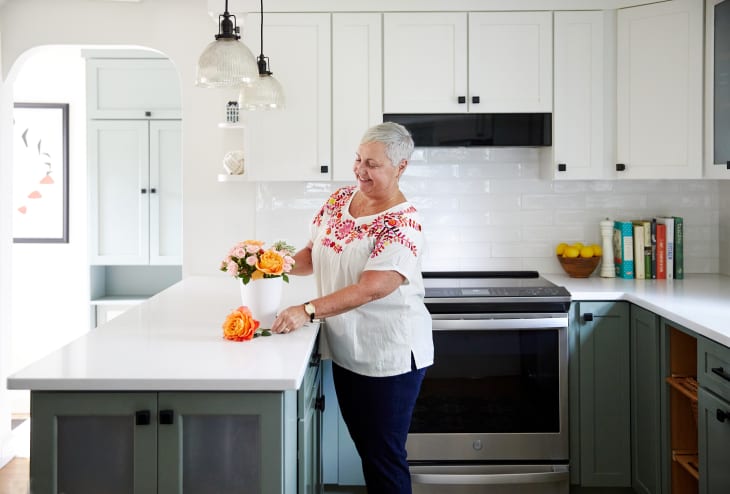 Peggy Barresi making a floral arrangement in her newly renovated kitchen.