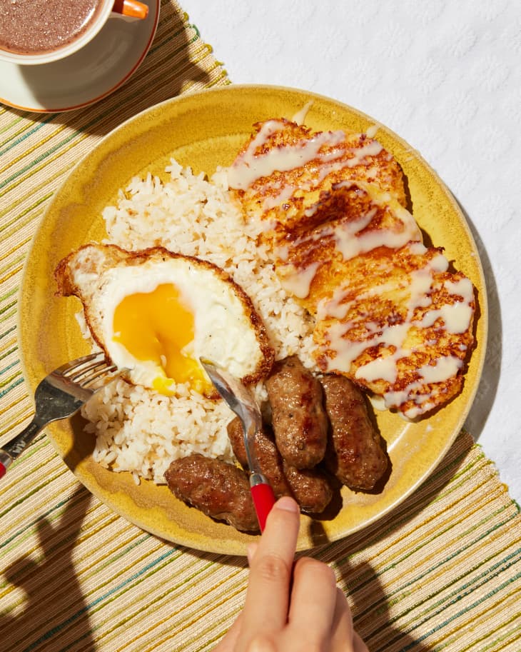 Someone slicing into egg on Silog plate