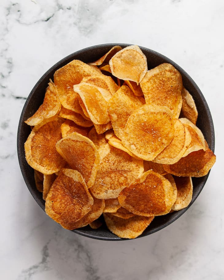 Homemade potato chips in a black bowl