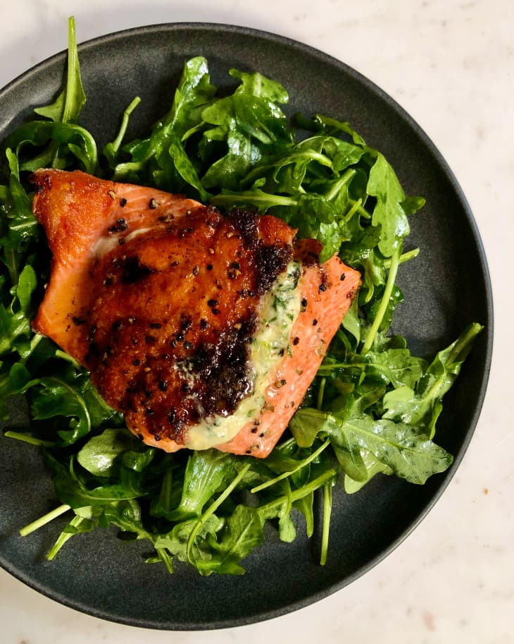 Salmon stuffed with spinach, cream, mozzarella and parmesan, pan-fried, plated on top of an arugula side salad