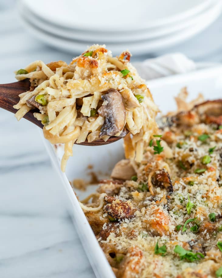 Turkey Tetrazzini in a white serving dish, with a serving spoon lifting a piece
