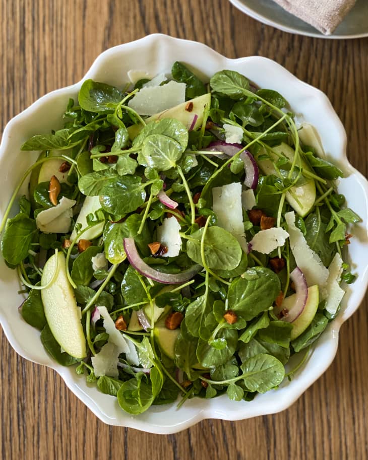 A closeup of a Watercress salad in a white dish