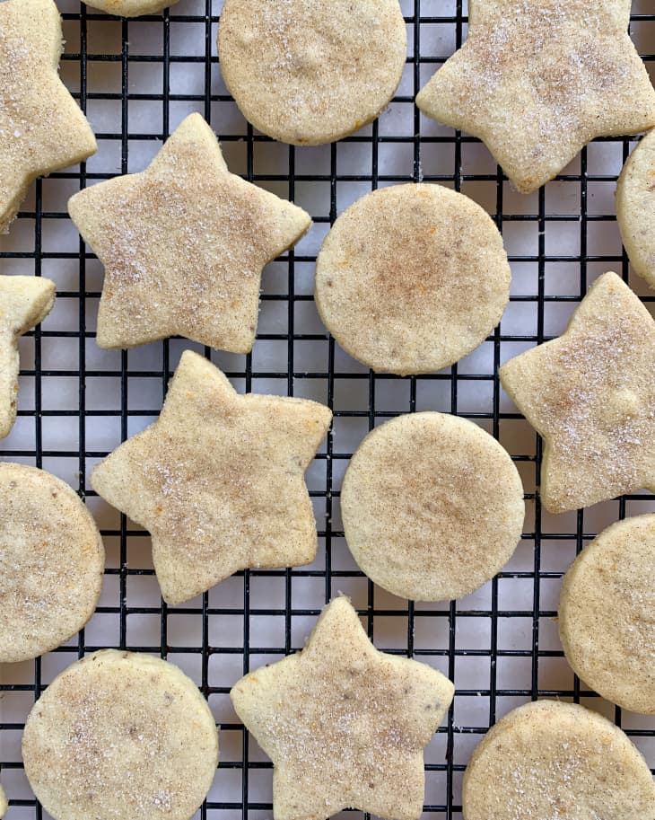 Biscochitos (Mexican biscuits or cookies) cut into circle and star shapes, spread across a cooling rack.