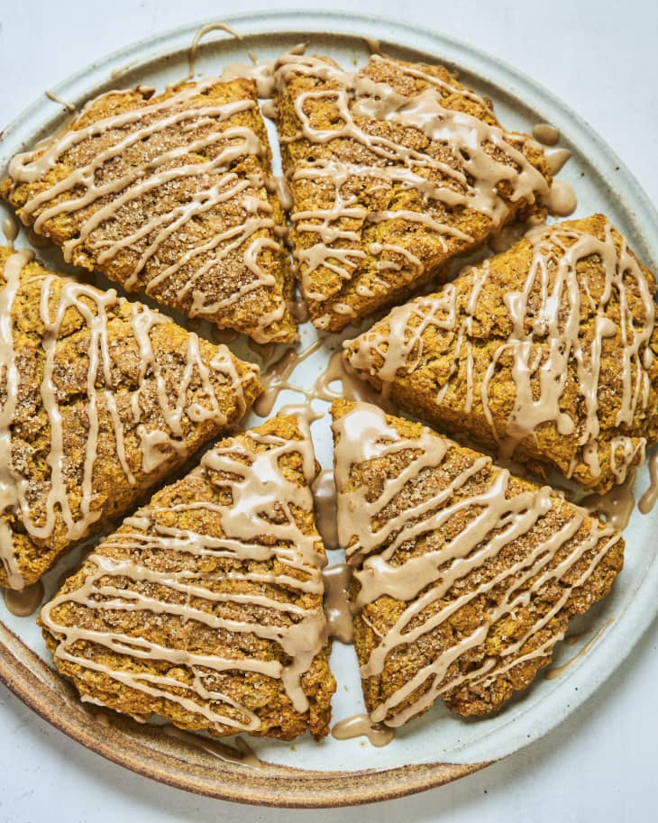 Pumpkin scone, baked into the round shape of a pie and then cut into six slices, with icing drizzled on top.