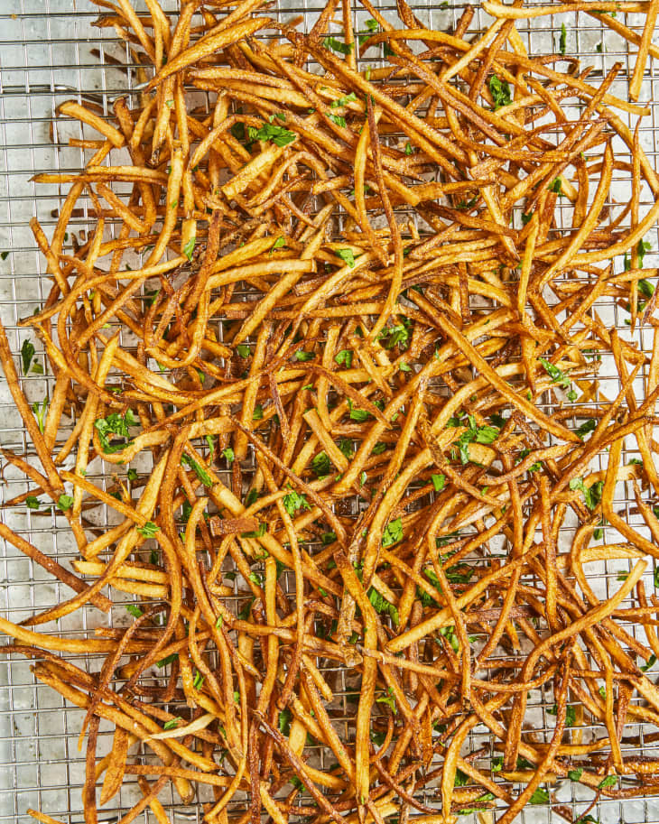 a pile of shoestring fries on a silver metal cooling rack