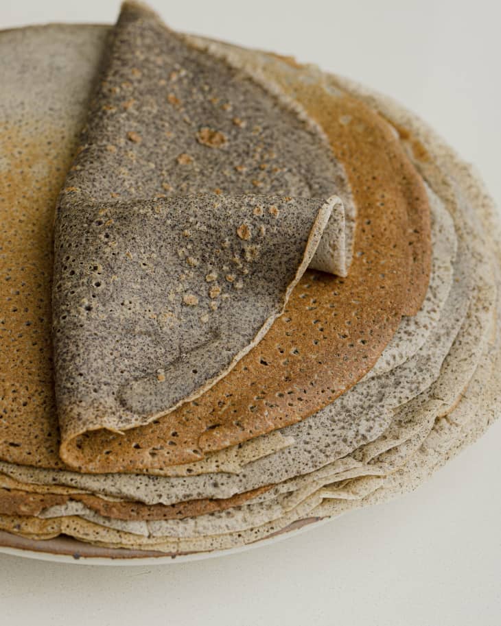 Buckwheat crepes, artfully and delicately folded in half, stacked on a plate