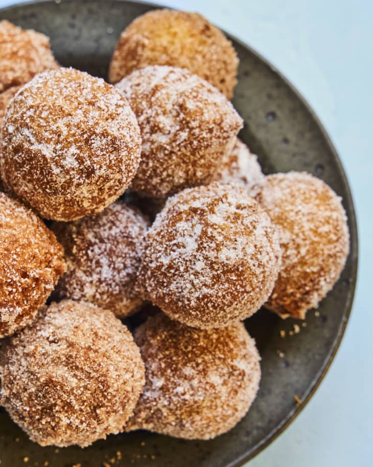 Donut holes on a plate, tossed in powdered sugar