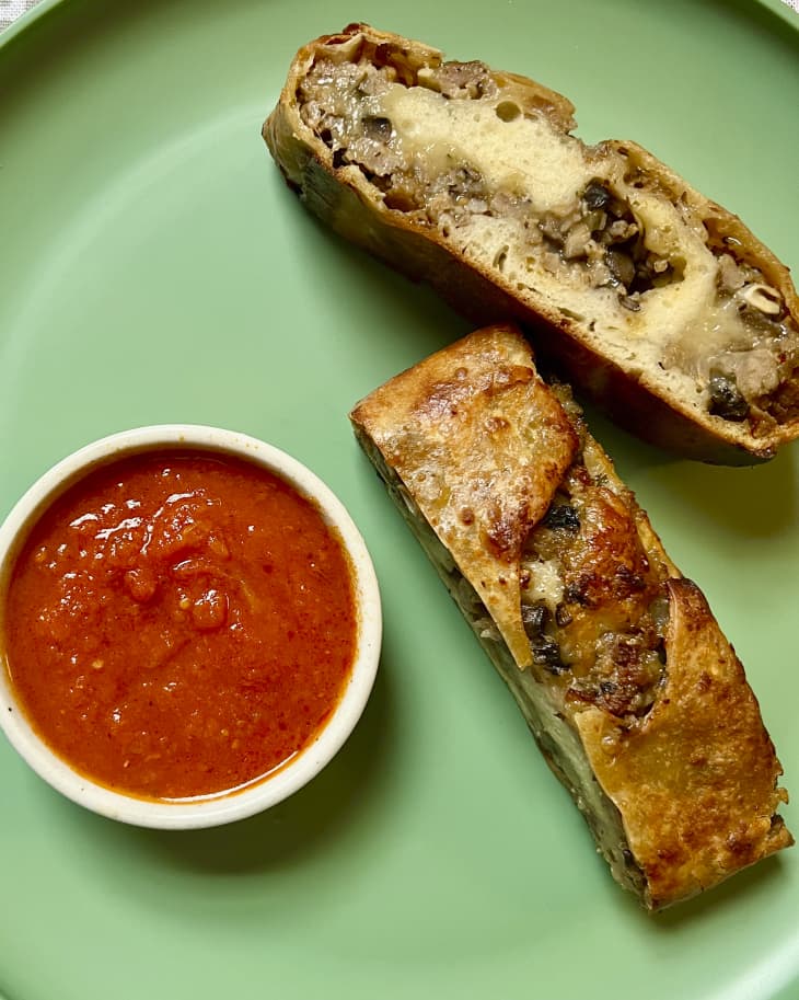 two slices of sausage bread on green plate with marinara sauce