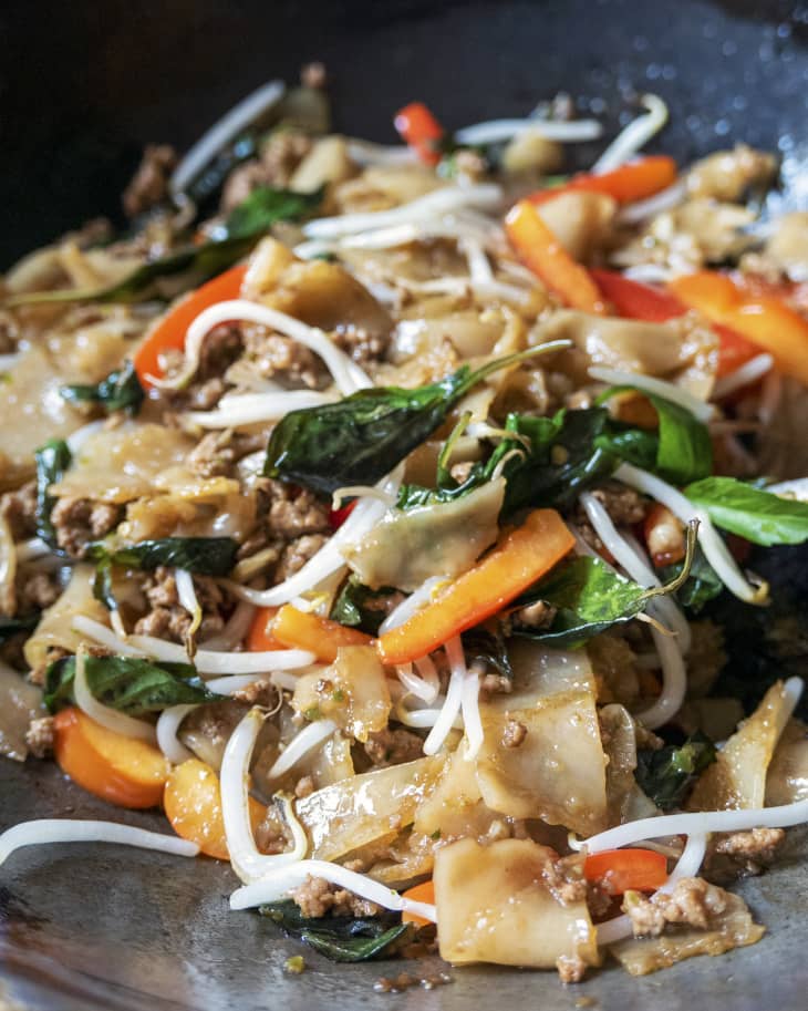 a closeup of Drunken Noodles (Pad Kee Mao) - a favorite Thai dish made with rice noodles and Thai basil, often eaten in Thailand on late nights after drinking)