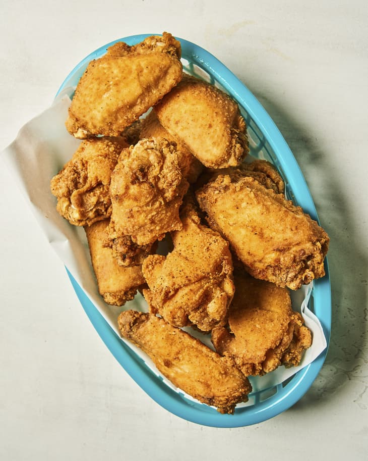 fried chicken wings in a turquoise basket,