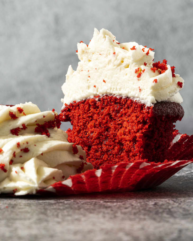 red velvet cupcakes with white icing and red velvet crumbs
