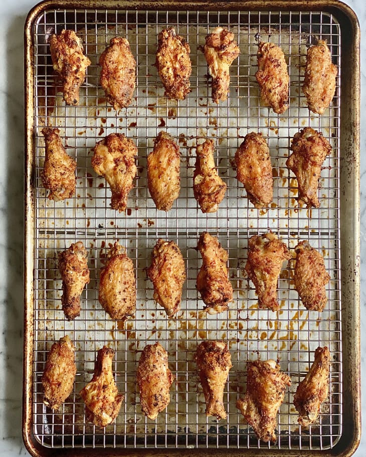 Four rows of six baked chicken wings on an oven rack