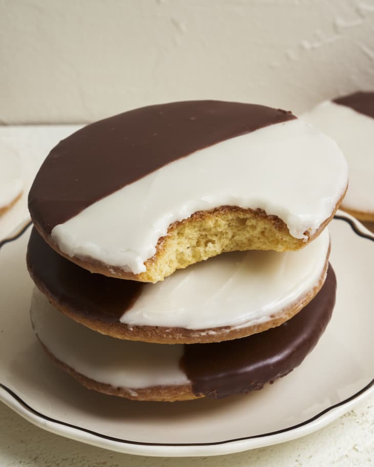 three  black and white cookies stacked, with the top one having a single bite out