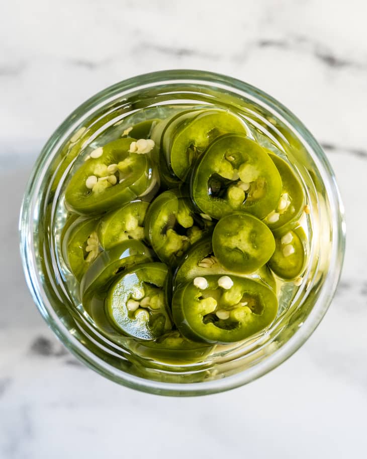 pickled jalapenos in a small glass jar