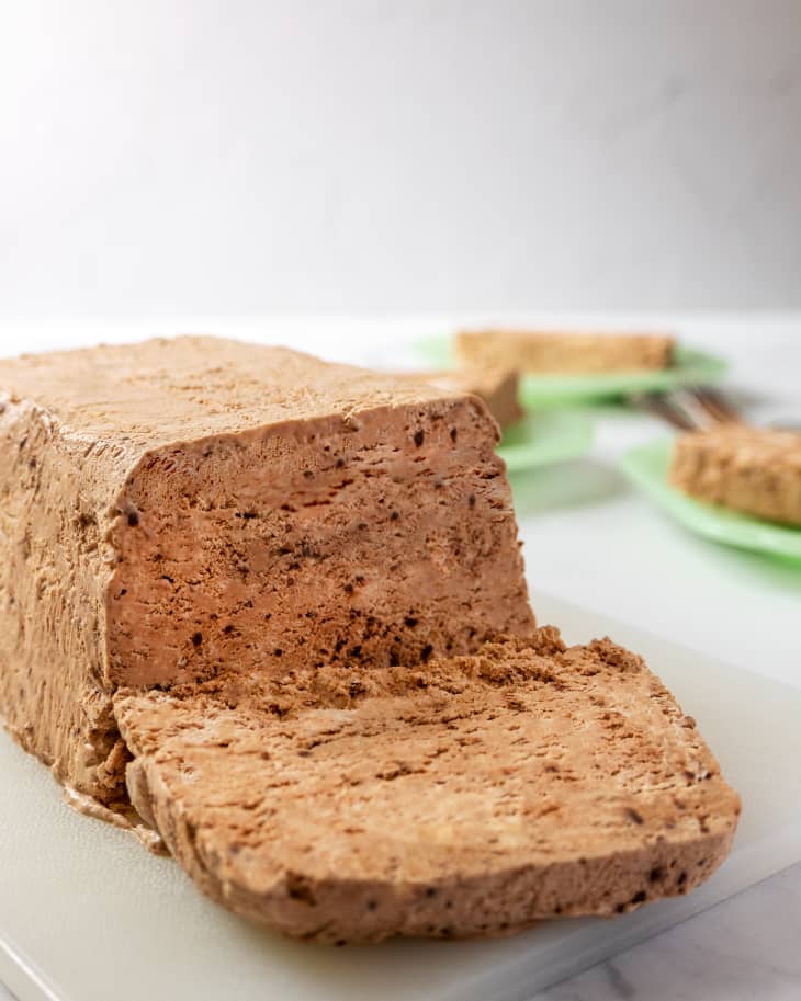 Semifreddo (a classic Italian frozen dessert that's halfway between ice cream and mousse) in a loaf, with one slice cut and laid down.