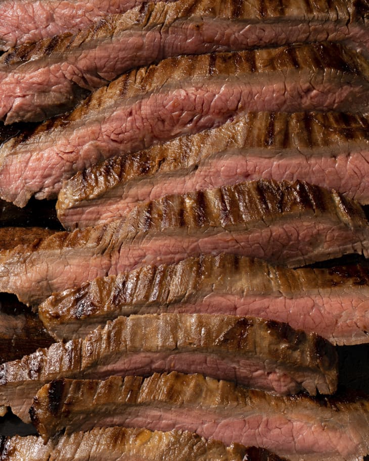 a closeup of medium rare, sliced, grilled, Flank steak