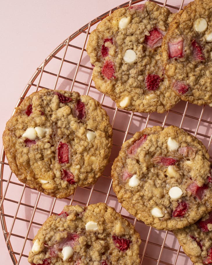 Strawberry cookies with white chocolate chips on a round, wire cooling rack