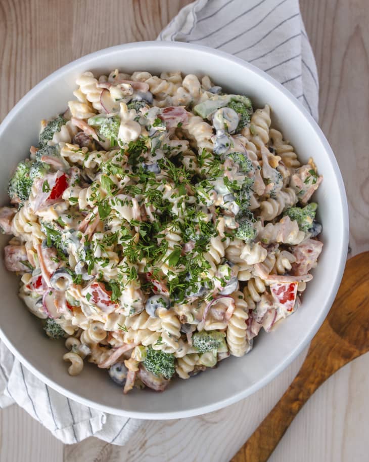 A photo of Ranch pasta salad with broccoli, red peppers and chopped parsley on top