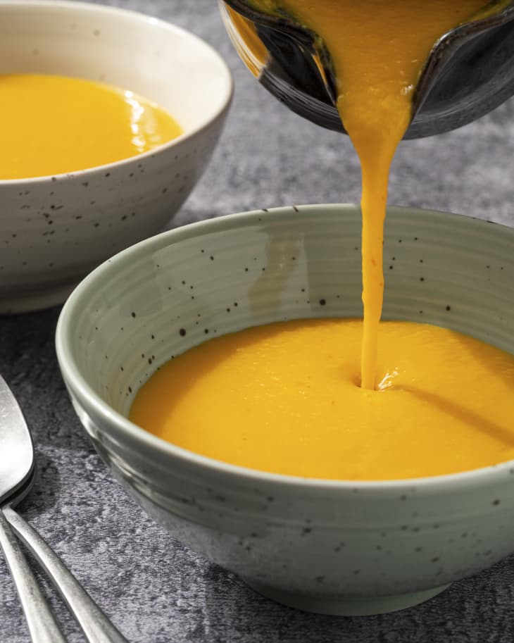 A photo of a bowl of Kabocha squash soup being poured.