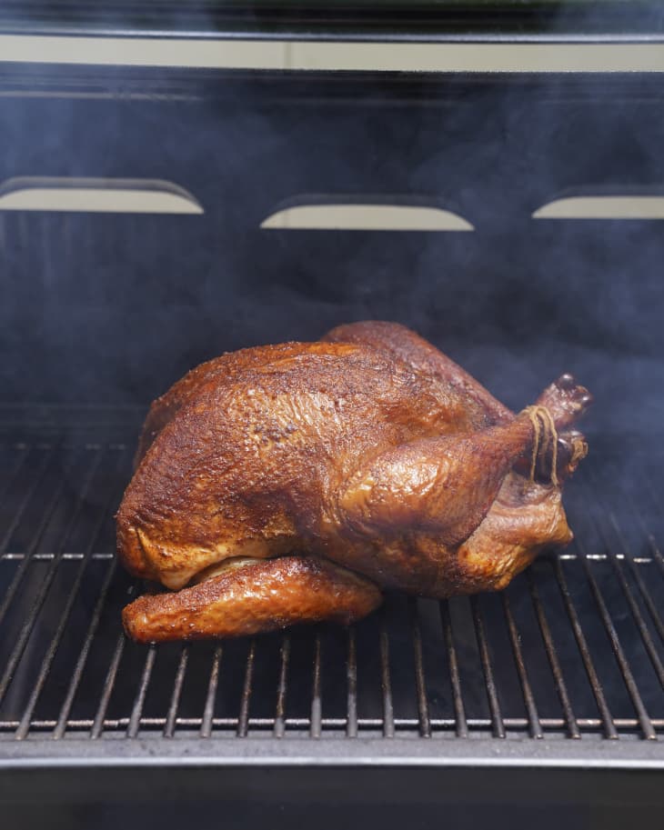 A photo of a whole smoked turkey in an oven with smoke