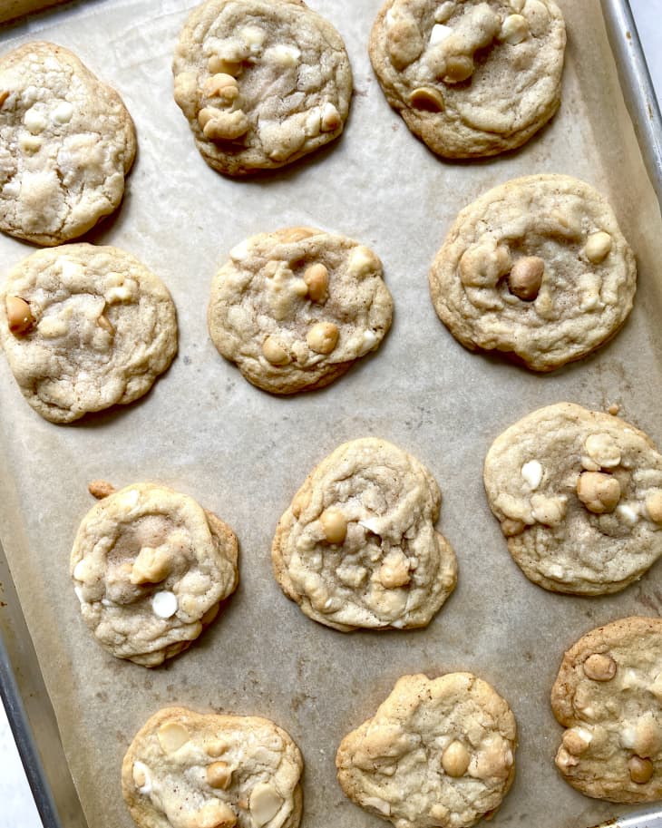 A photo of a baking sheet with macadamia nut cookies.
