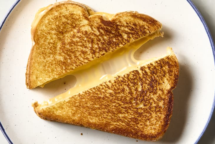 overhead shot of a grilled cheese sandwich cut diagonally, with a cheese pull.