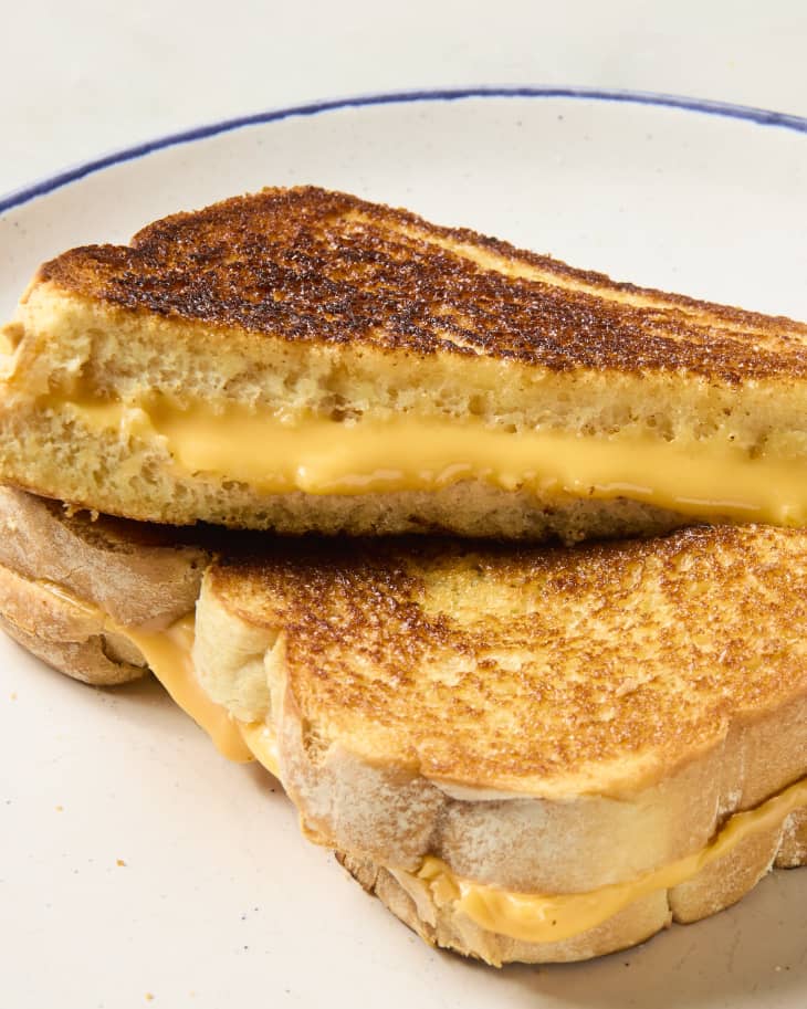 two halves of a grilled cheese sandwich, leaning on each other.