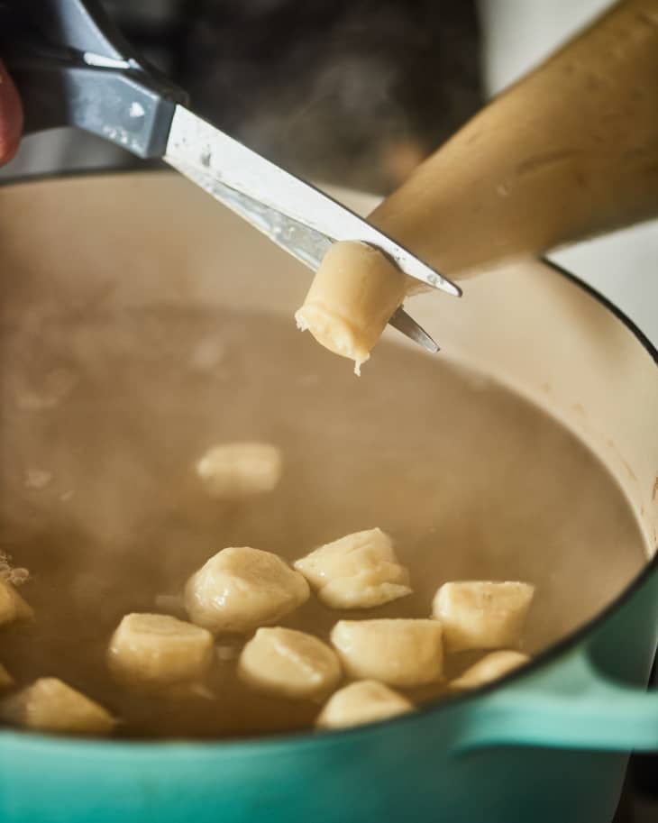 piping gnocchi into pot of hot water