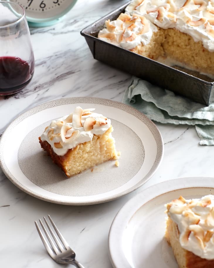 As the clock stretches past 7pm, slices of tres leches cake sit on plates next to the pan of cake and a glass of red wine.