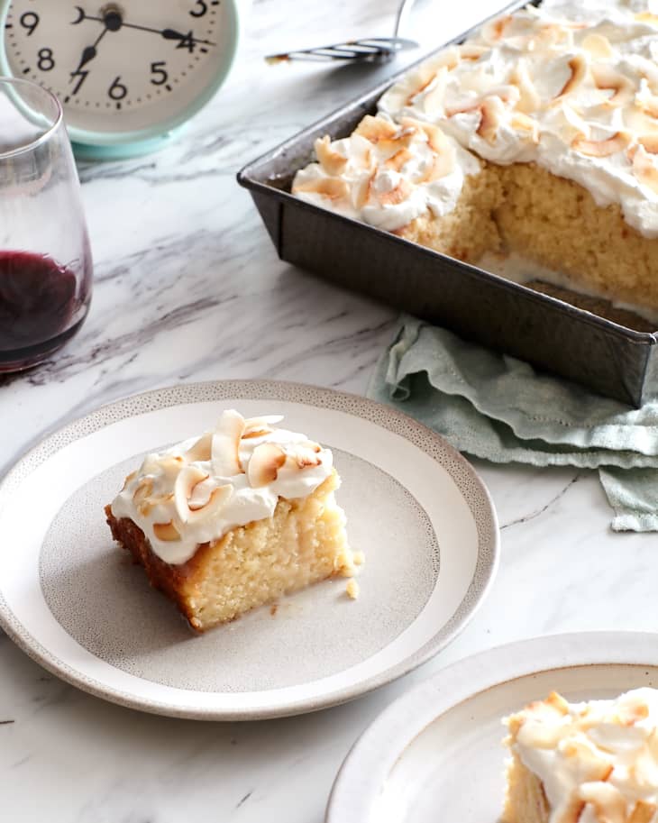 As the clock stretches past 7pm, slices of tres leches cake sit on plates next to the pan of cake and a glass of red wine.