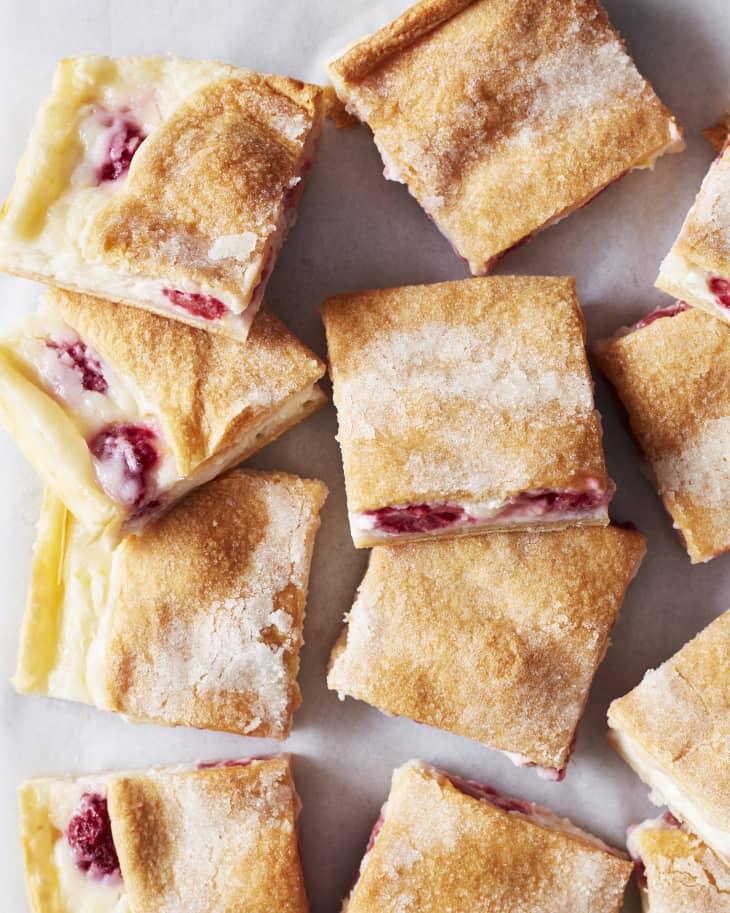Lemon raspberry cream cheese bars stacked on top of one another.