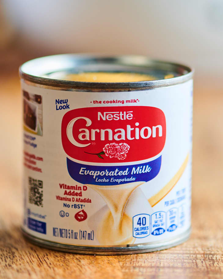 Can of carnation evaporated milk on wood surface