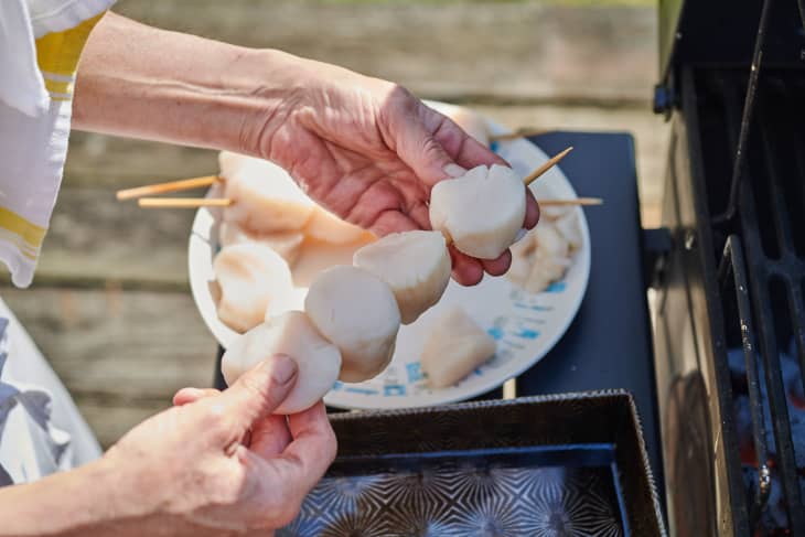 putting scallops onto a skewer