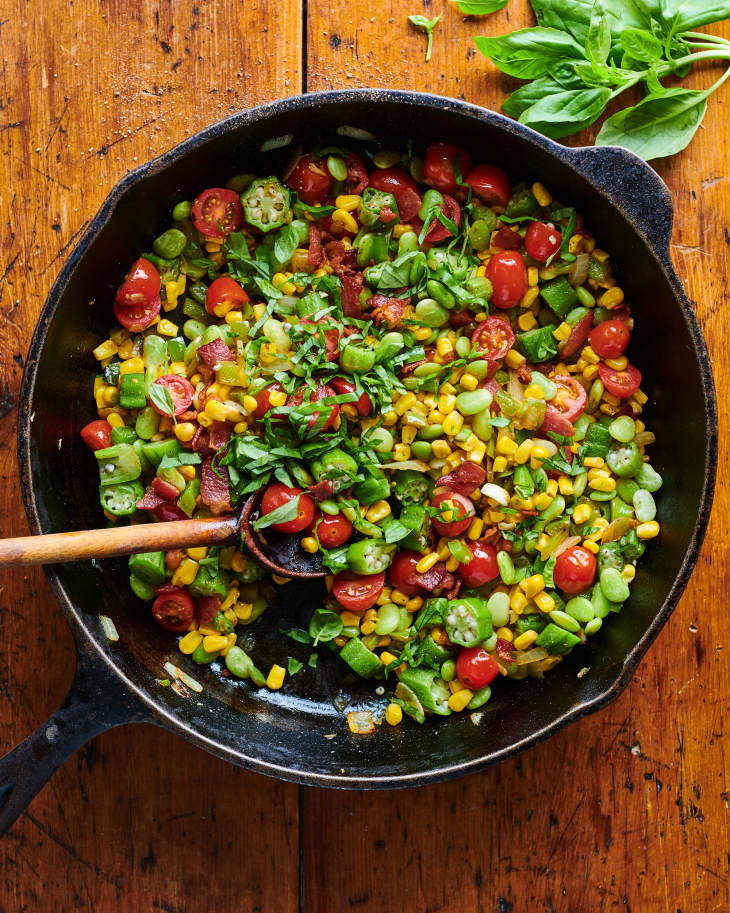 Succotash in cast iron pan topped with basil