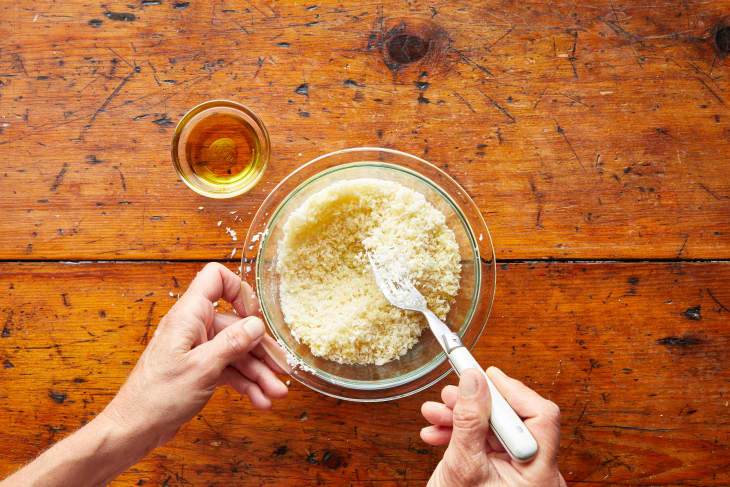 someone stirring olive oil into a bowl of Panko bread crumbs