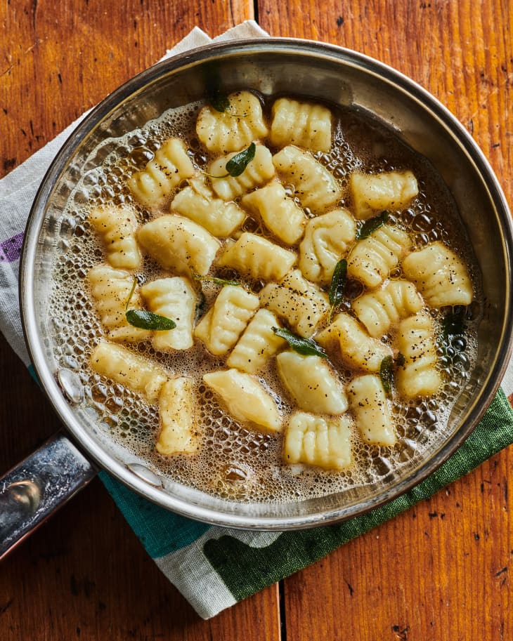 Gnocchi in pan of brown butter sage sauce.