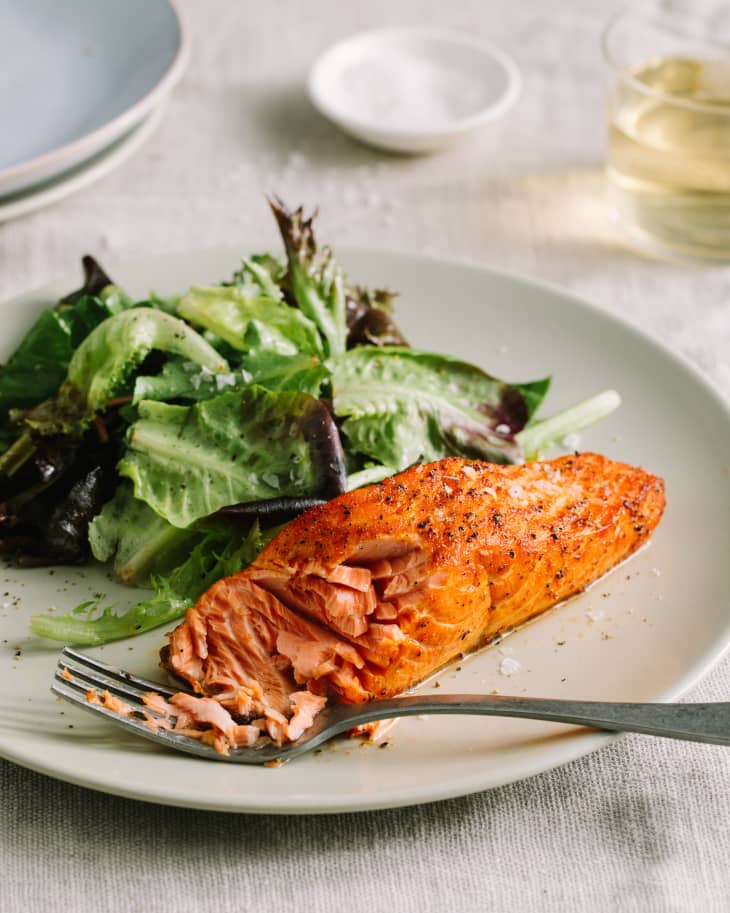 Perfect air fryer salmon plated with a side salad.