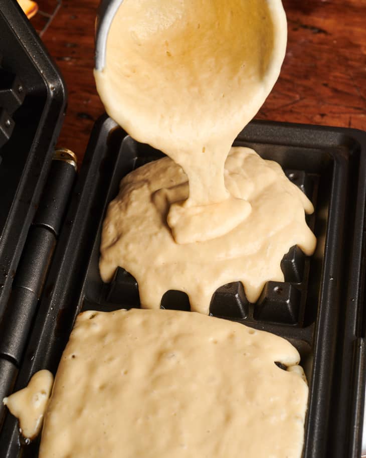 Crisp and fluffy waffle batter being poured into waffle iron.
