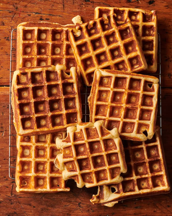 Crisp and fluffy Belgian waffles stacked on cooling rack.
