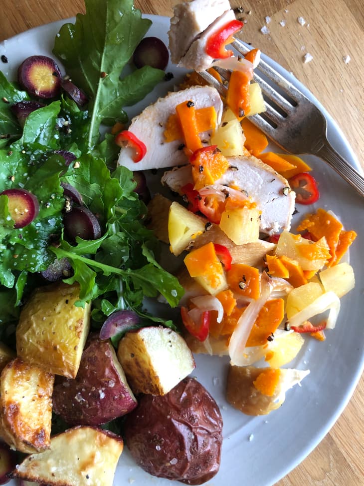 Chicken, roasted potatoes and salad topped with fermented vegetables.