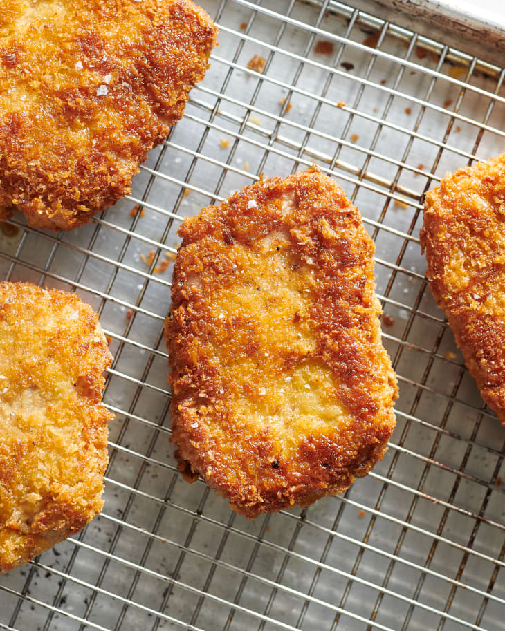 parmesan crusted pork chops sit on a cooling rack