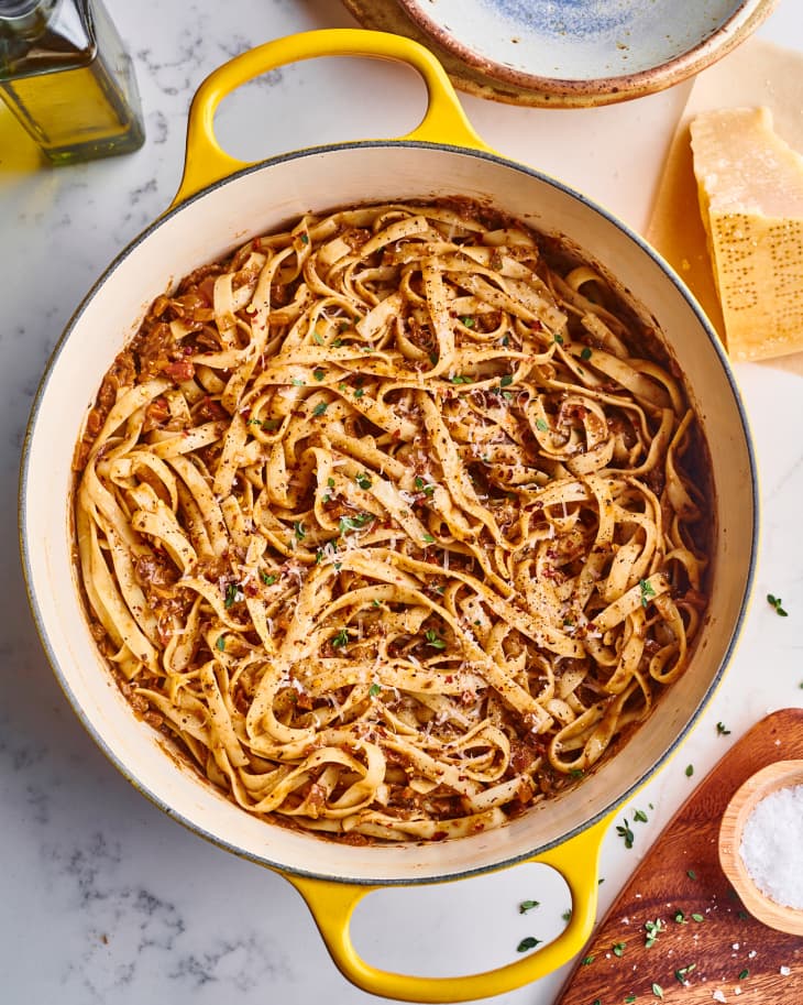 fettuccini and bolognese are mixed together in a large cooking pot