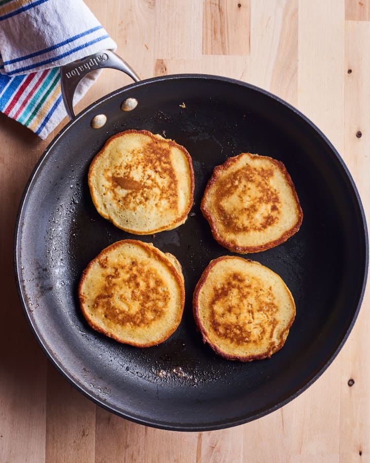 four fonio pancakes sit in a cast iron pan