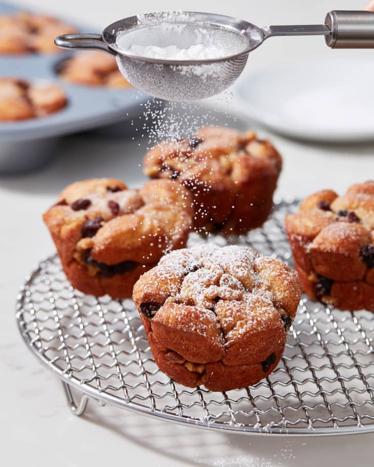 Powdered sugar being dusted on muffins.