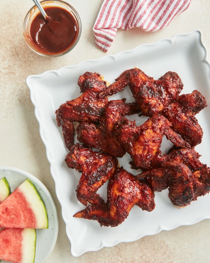 wings on a plate next to watermelon