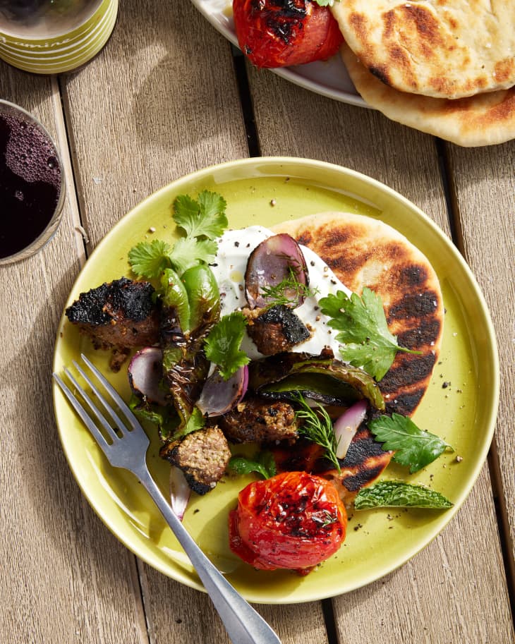 persian kebabs next to pita on a plate